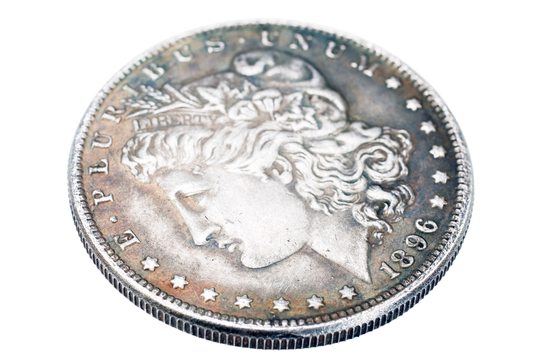 An 1896 Morgan silver dollar showing the profile of Lady Liberty with a natural aged patina on a white background.