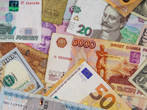 Assortment of global paper currencies including U.S. dollars, Euros, Rubles, and more, representing fiat currency diversity and economic fluctuation.