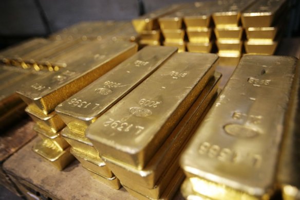 Stacks of large gold bars arranged on a pallet in a storage area.
