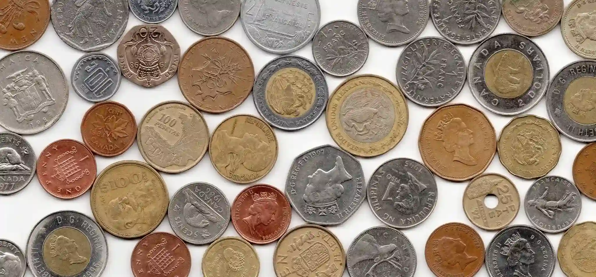 Assorted world coins from various countries are displayed on a white background for a global coin collection.