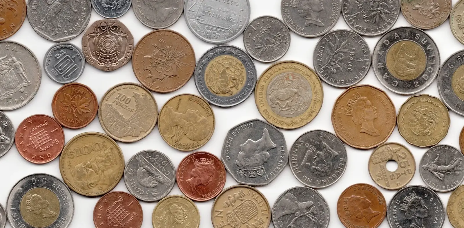 A colorful assortment of vintage international coins, featuring various currencies from Canada, Mexico, Europe, and other global regions.