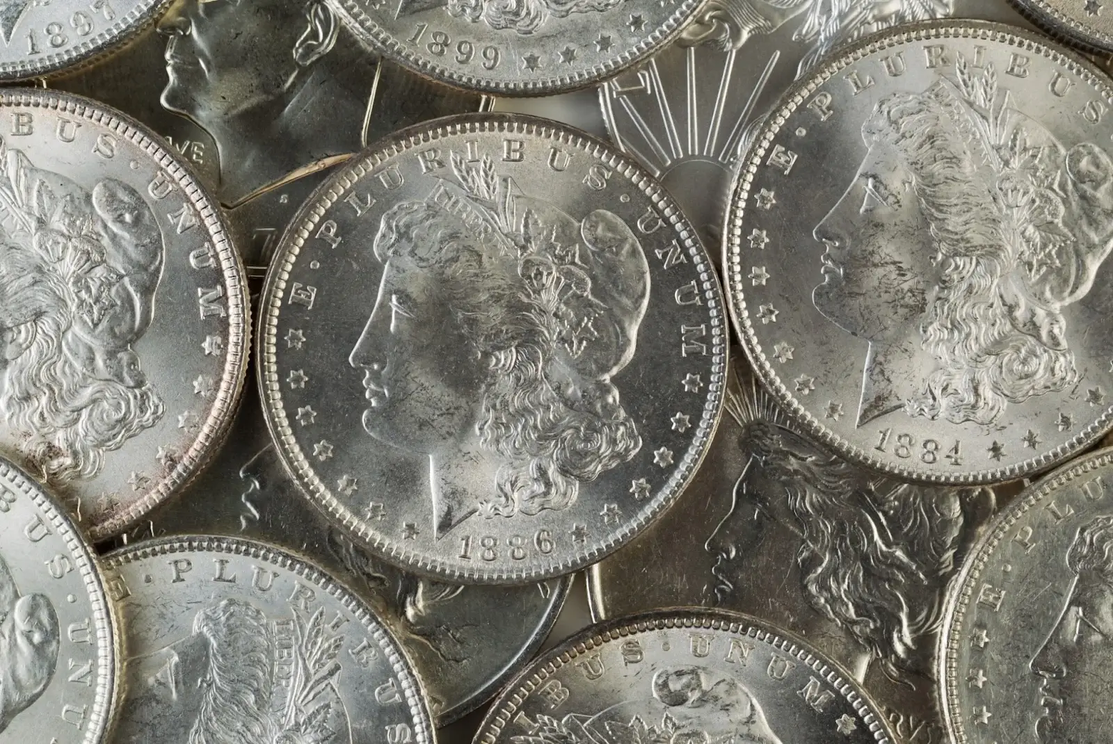 A close-up view of circulated Morgan Silver Dollars from the late 1800s, showcasing the iconic Lady Liberty design and detailed minting.