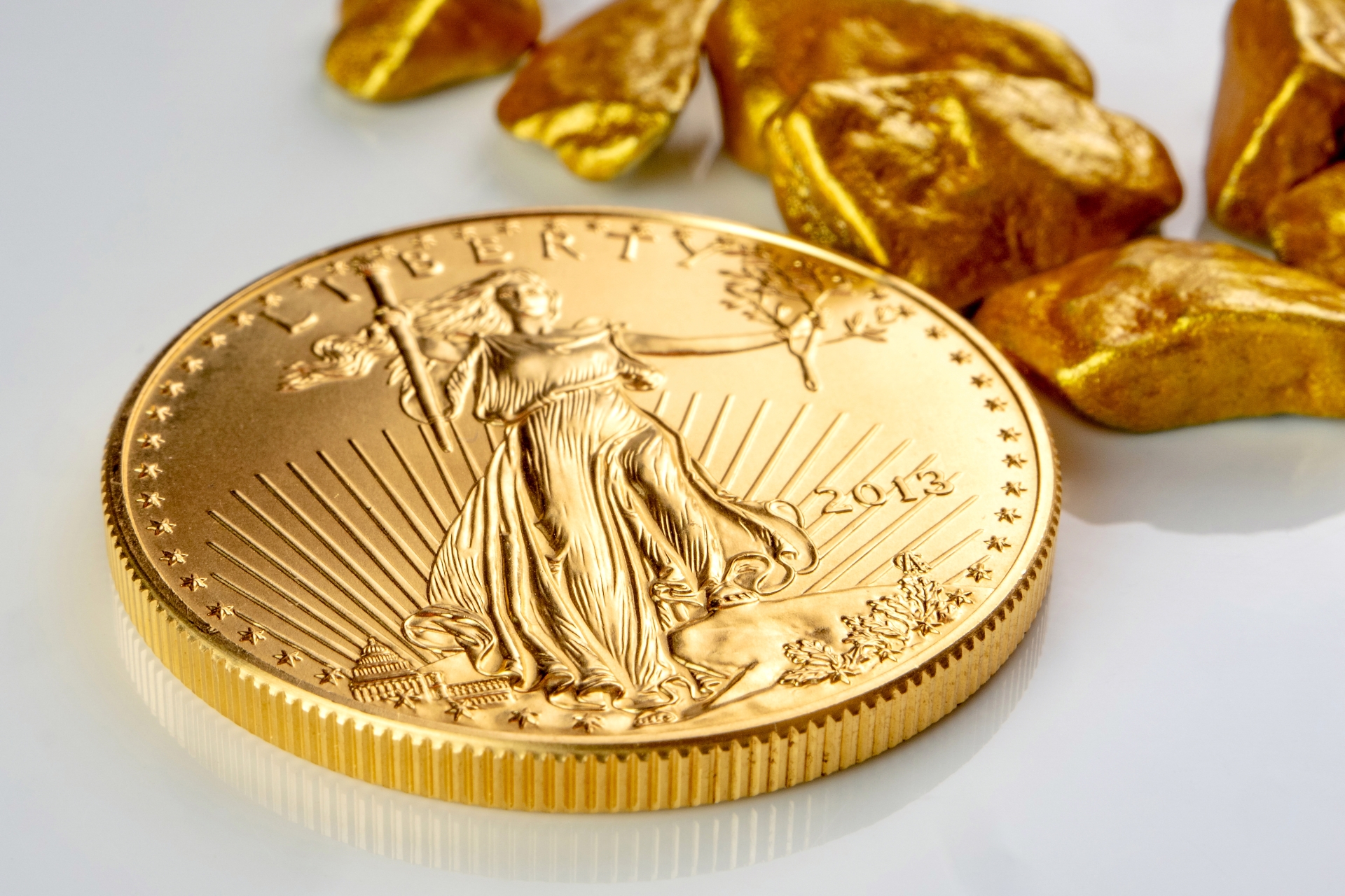 Obverse side of a 2013 gold American Eagle coin featuring Lady Liberty, positioned with gold nuggets.