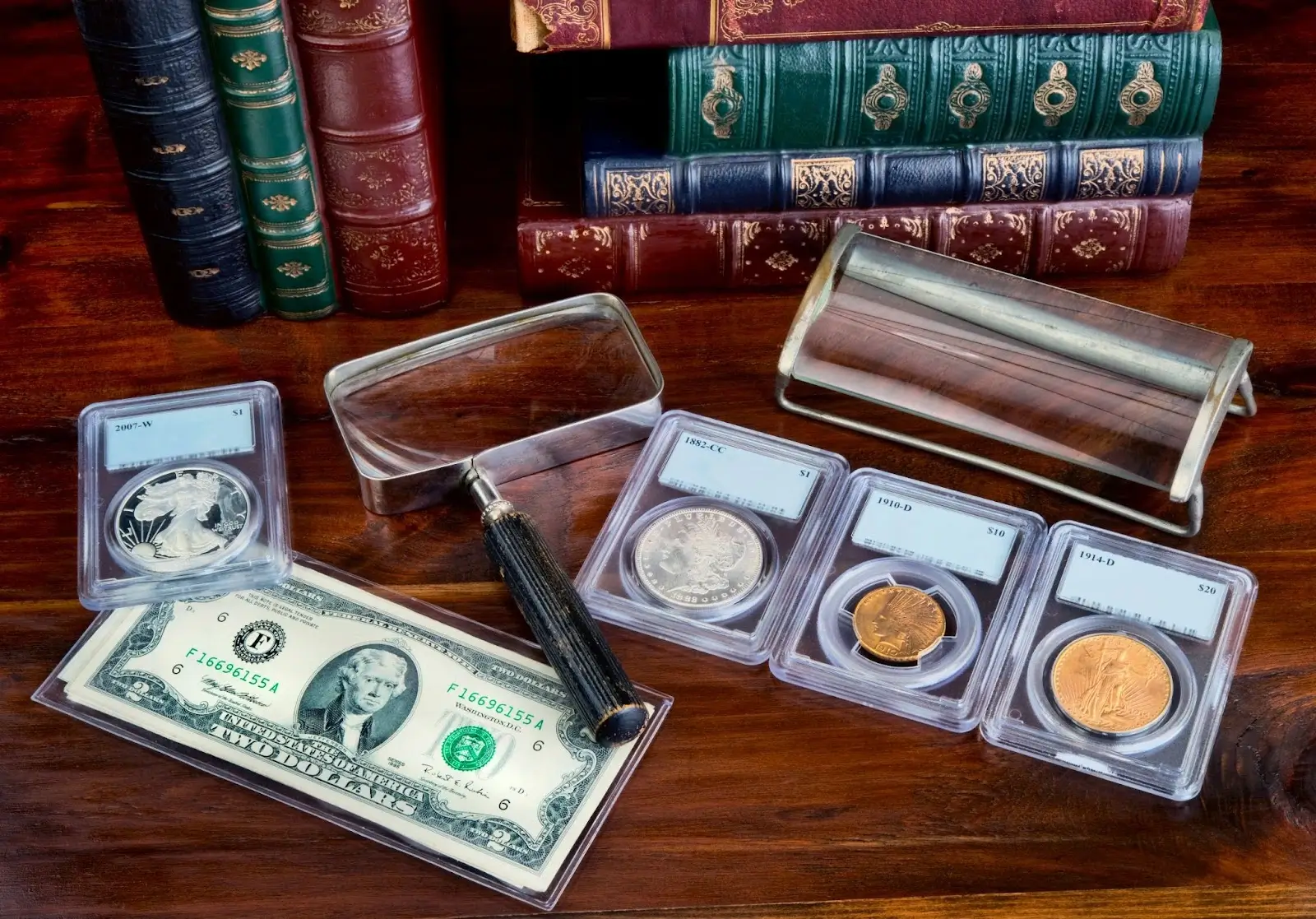 Coins, dollar bills, and a magnifying glass displayed alongside vintage books, highlighting a collector's items and valuable currency.